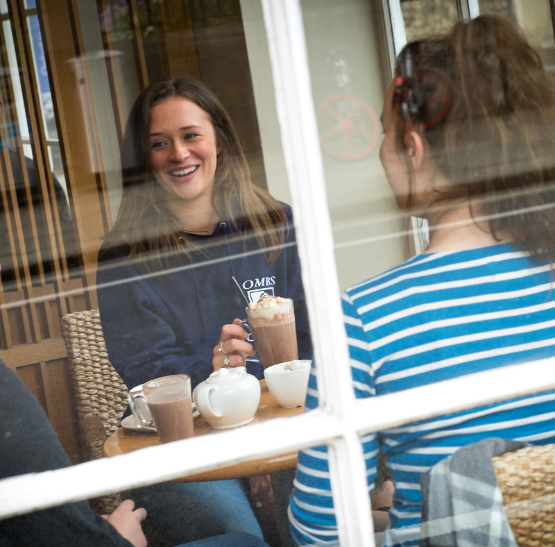 Graduate Careers In Business - three teenages sat in a cafe together smiling